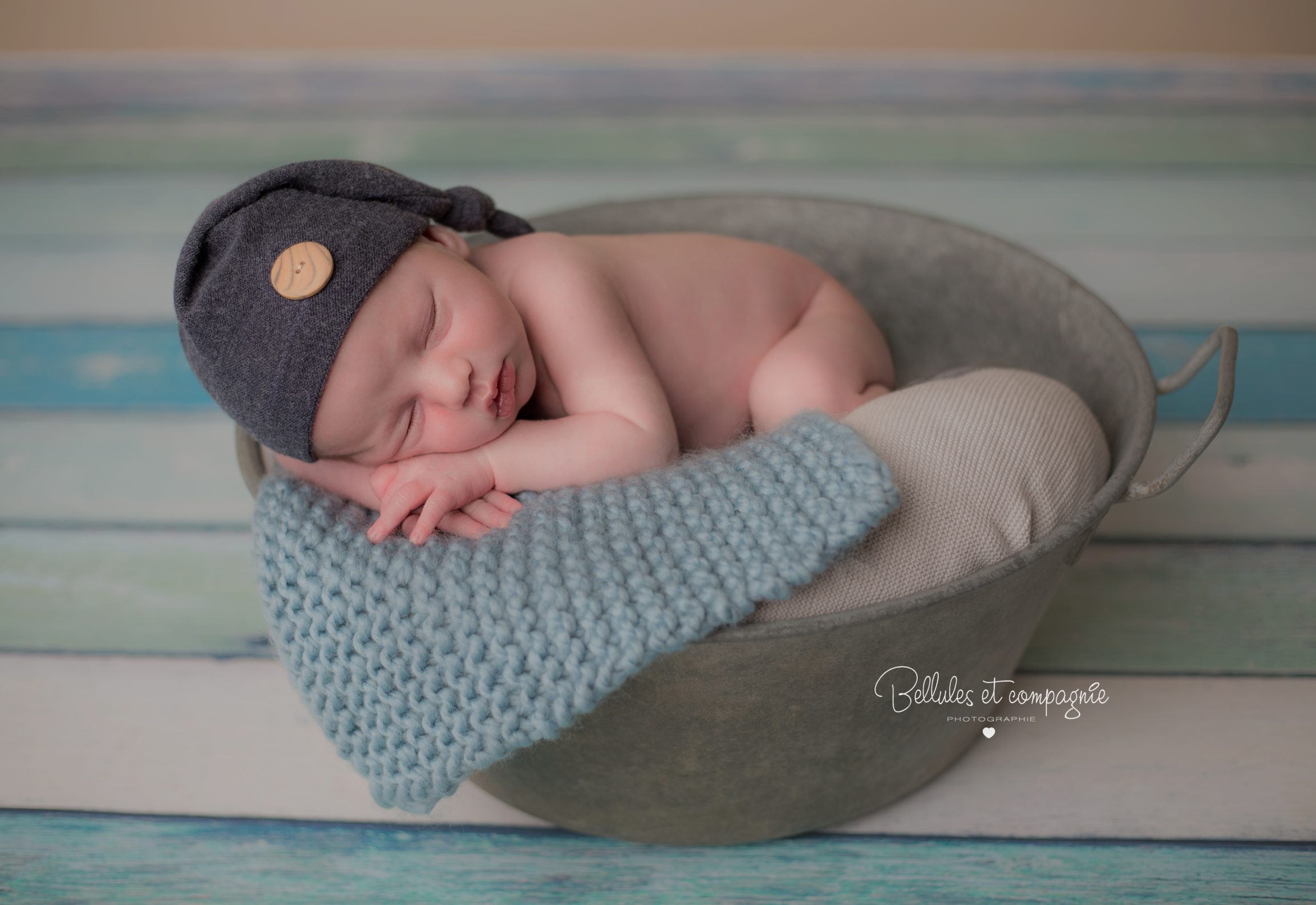 Nouveau-né dans un contenant bassine lors d'une séance de la photographe naissance bellules et compagnie à Clermont-Ferrand