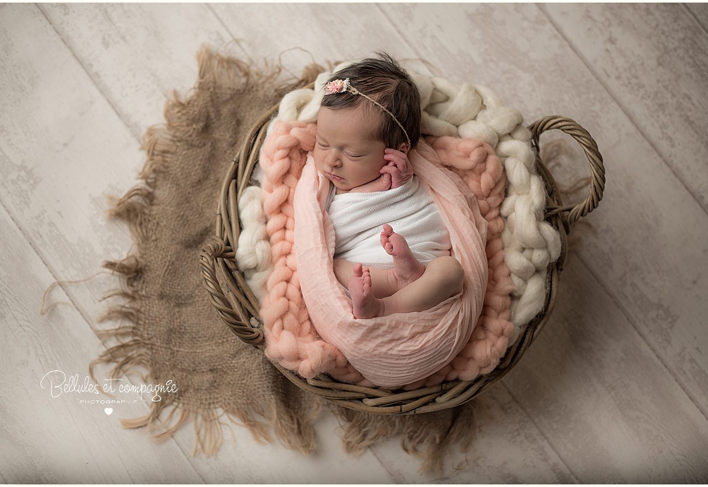 Bébé dans un panier couleur saumon pour une séance newborn posing par photographe Bellules et Compagnie à Clermont-Ferrand