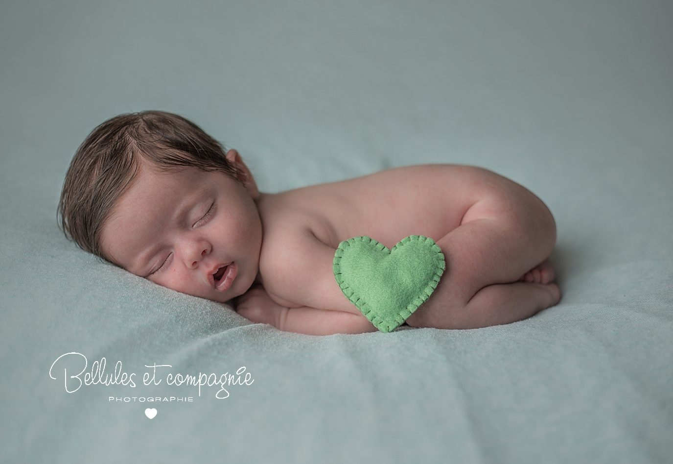 nouveau-né avec coeur vert par la photographe de naissance Bellules et Compagnie à Cournon d'Auvergne