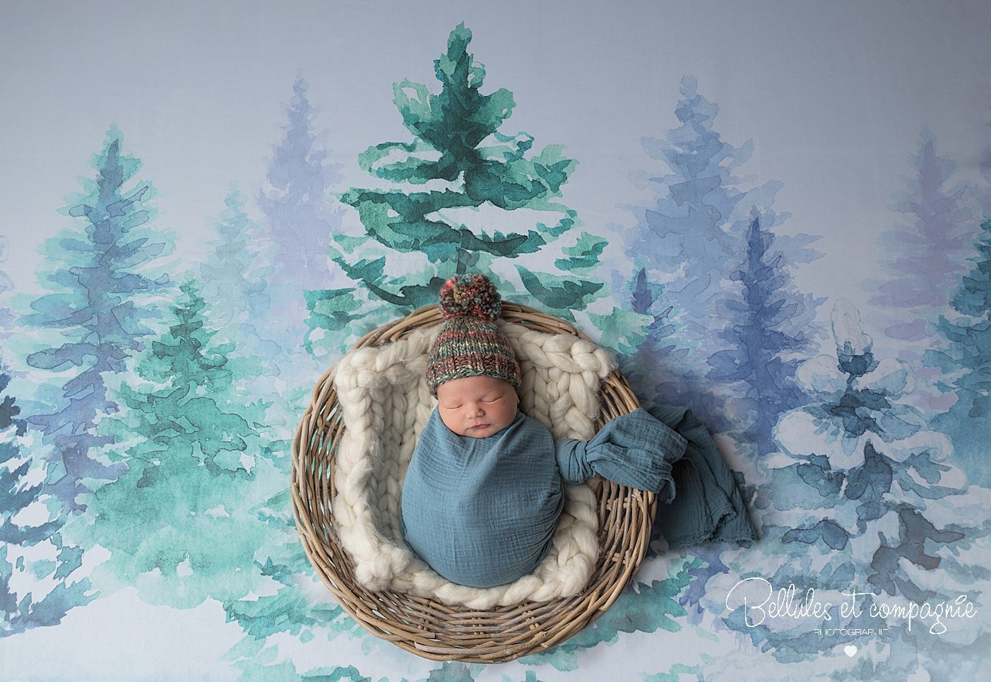 Mise en scène d'un nouveau-né avec un joli bonnet sur fond enneigé par Bellules et compagnie photographe dans le puy-de-Dôme